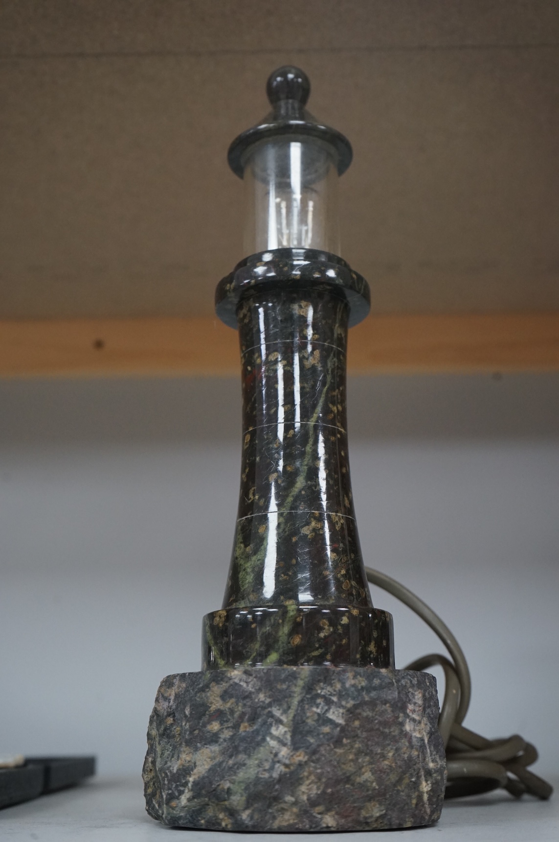 A Cornish serpentine lamp in the form of a lighthouse, 29cm high